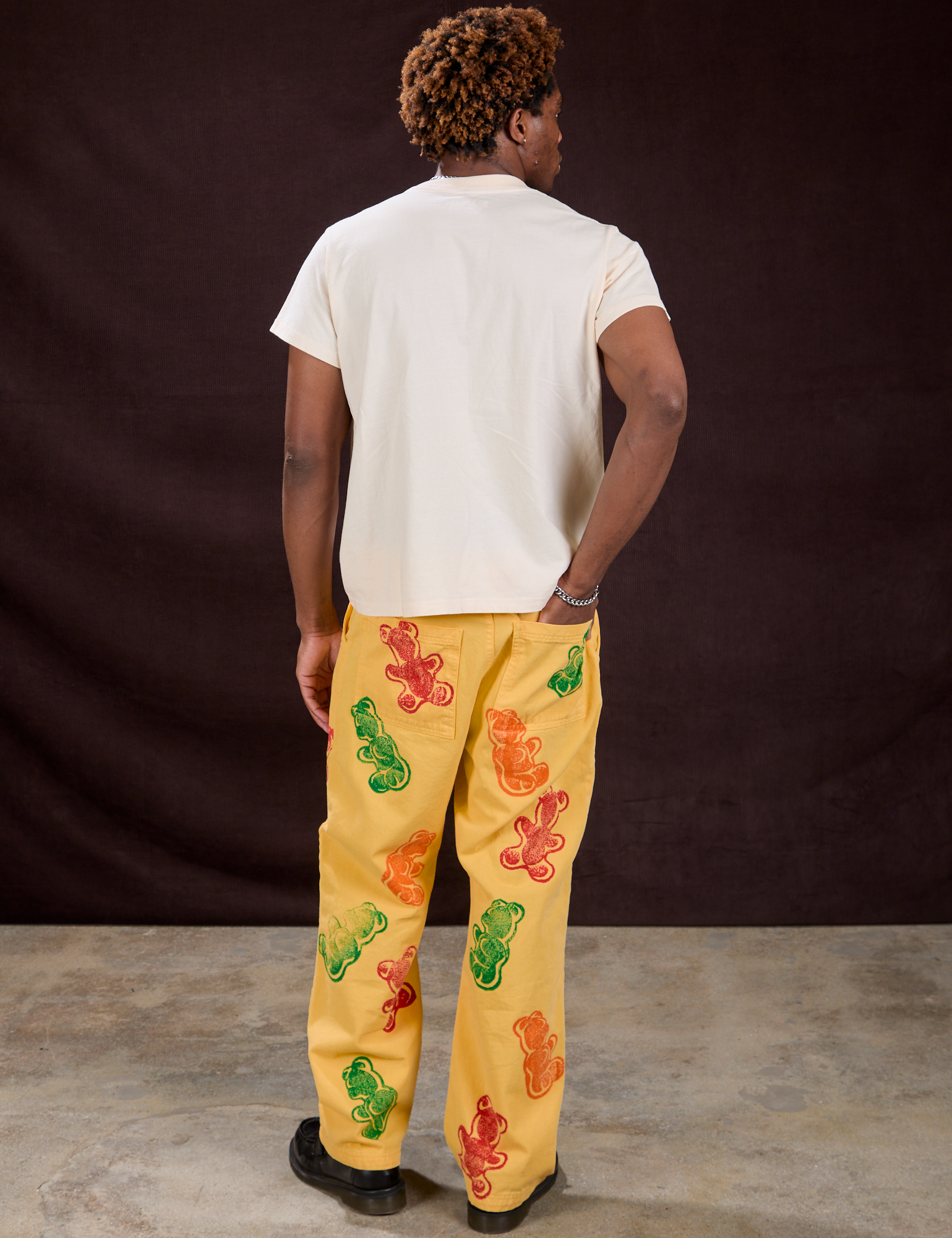 Back view of Gummy Bear Paintstamped Work Pants in Butter Yellow and Organic Vintage Tee in Vintage Off-White