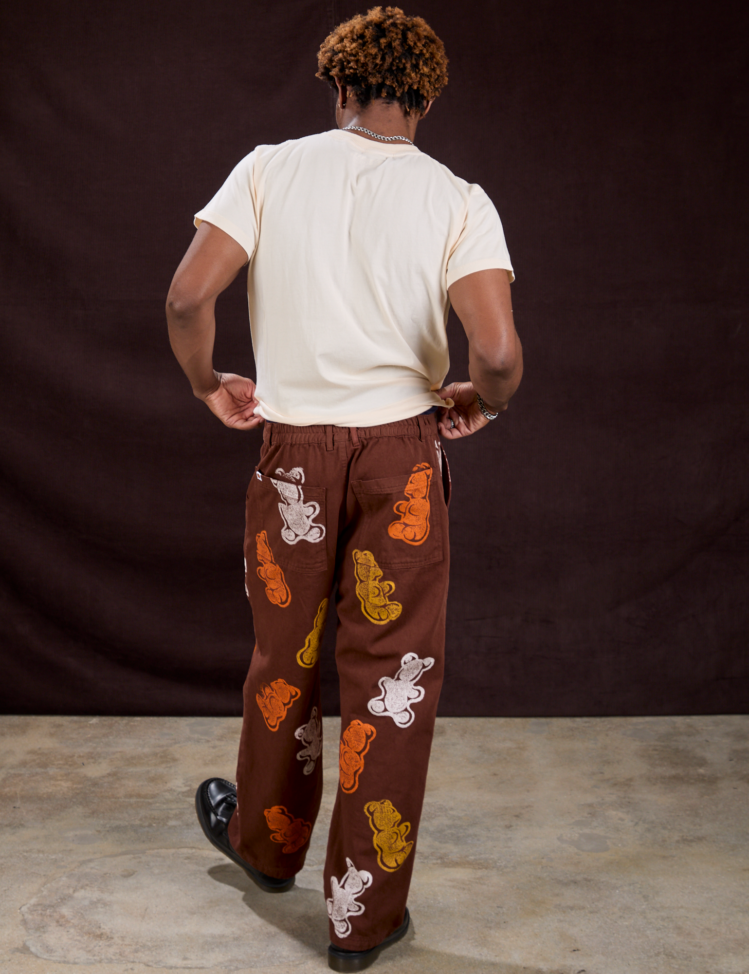 Back view of Gummy Bear Paintstamped Work Pants in Fudgesicle Brown and Organic Vintage Tee in Vintage Off-White