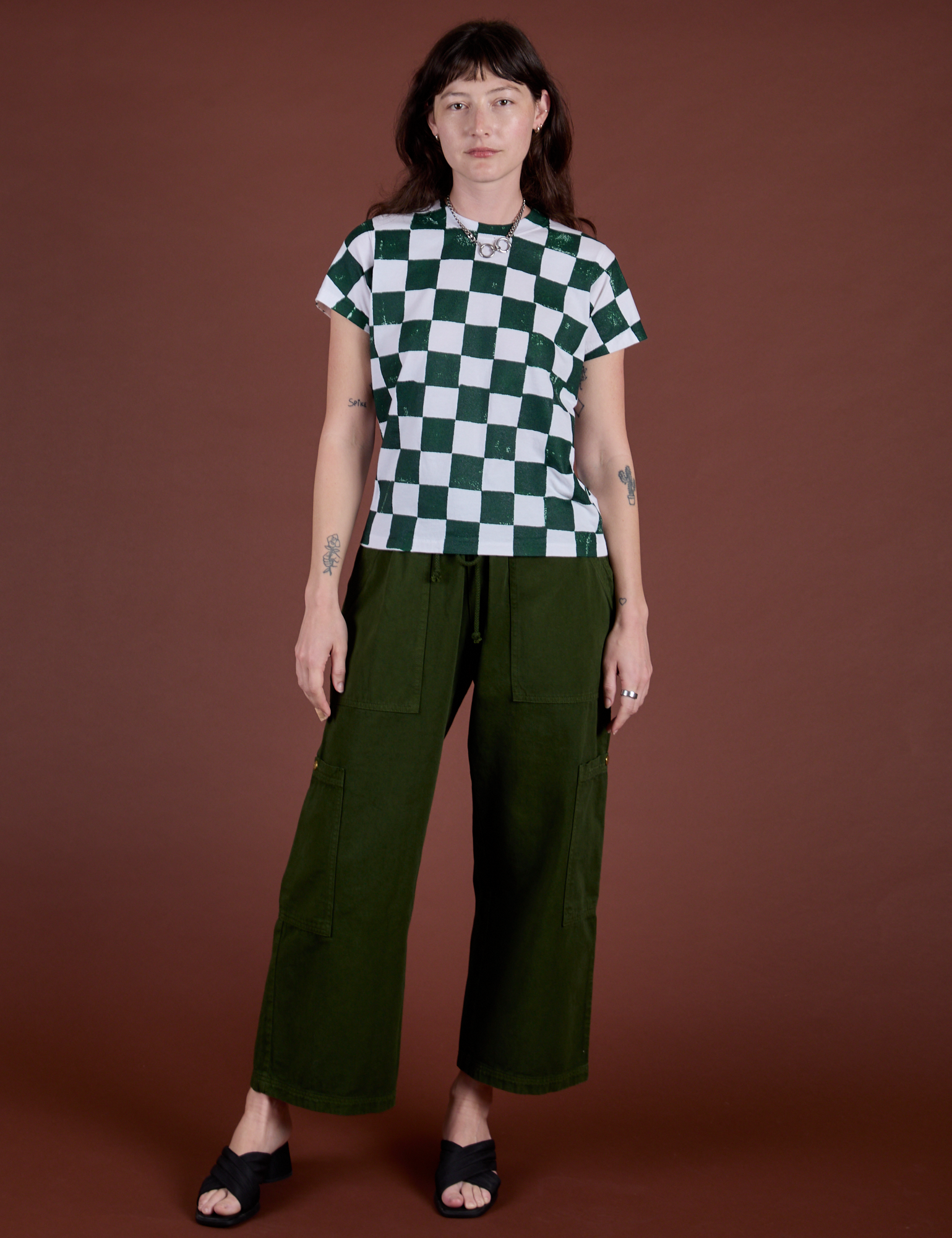 Alex is wearing Checker Organic Tee in Swamp Green and evergreen Drop Pocket Cargo Pants