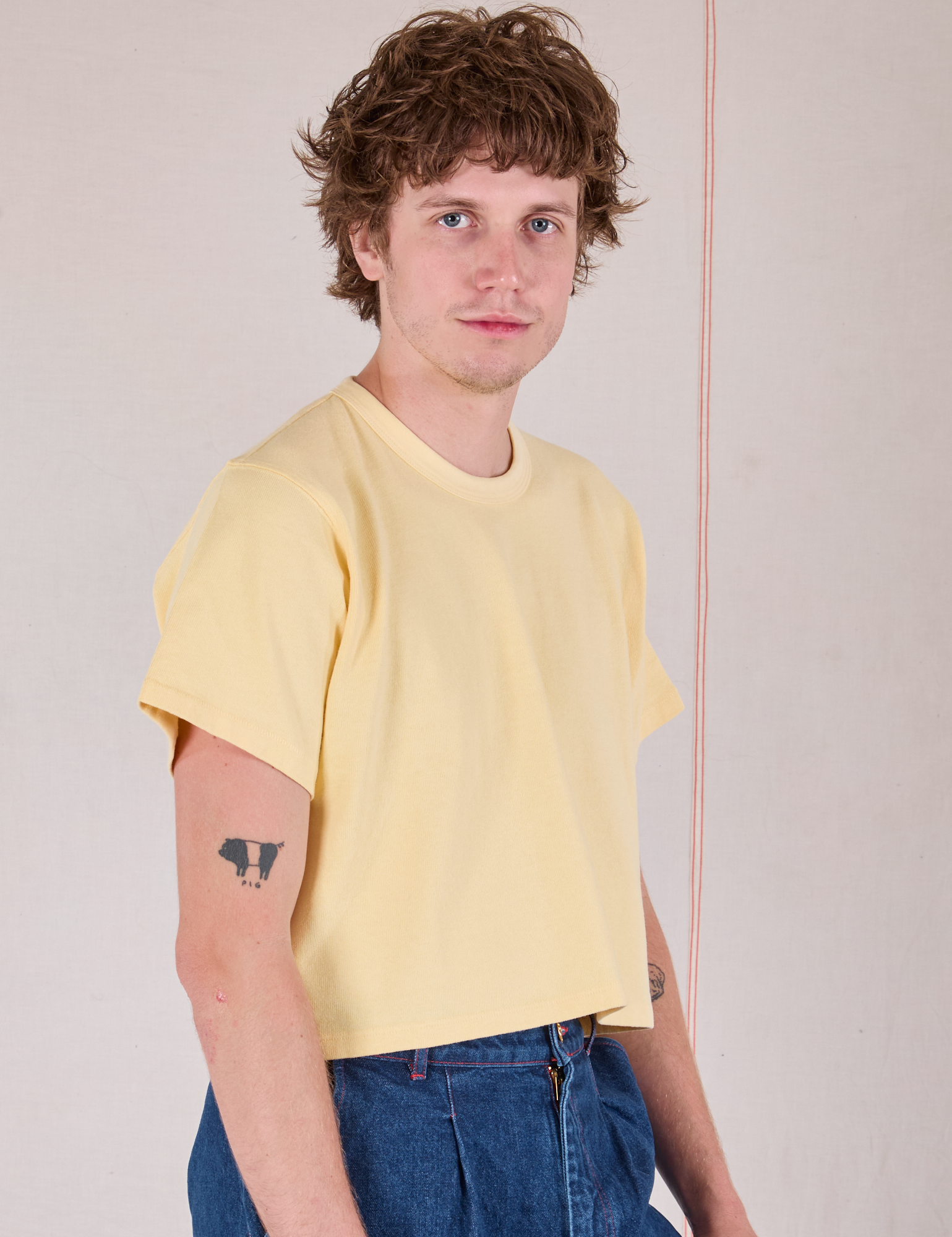 Cropped Burly Tee in Butter Yellow angled front view on Quinn