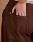Close up of Juliet's hand in the back pocket of Drop Pocket Cargo Pants in Fudgesicle Brown