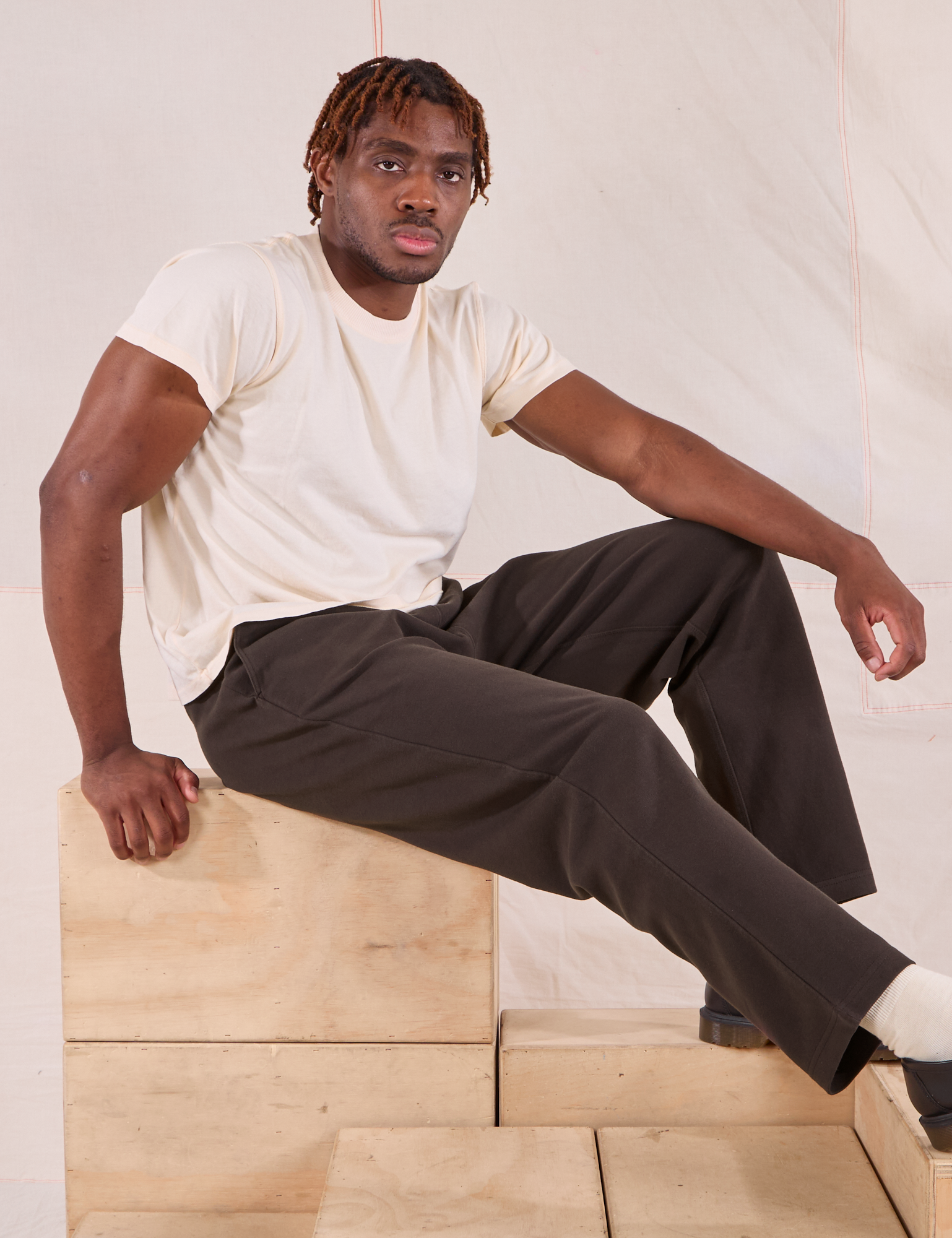 Issac is wearing Easy Pants in Espresso Brown and Organic Vintage Tee in vintage tee off-white