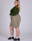 Side view of Pleated Trouser Shorts in Khaki Grey and evergreen Long Sleeve Burly Tee on Juliet