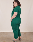 Angled back view of Petite Short Sleeve Jumpsuit in Hunter Green worn by Ashley