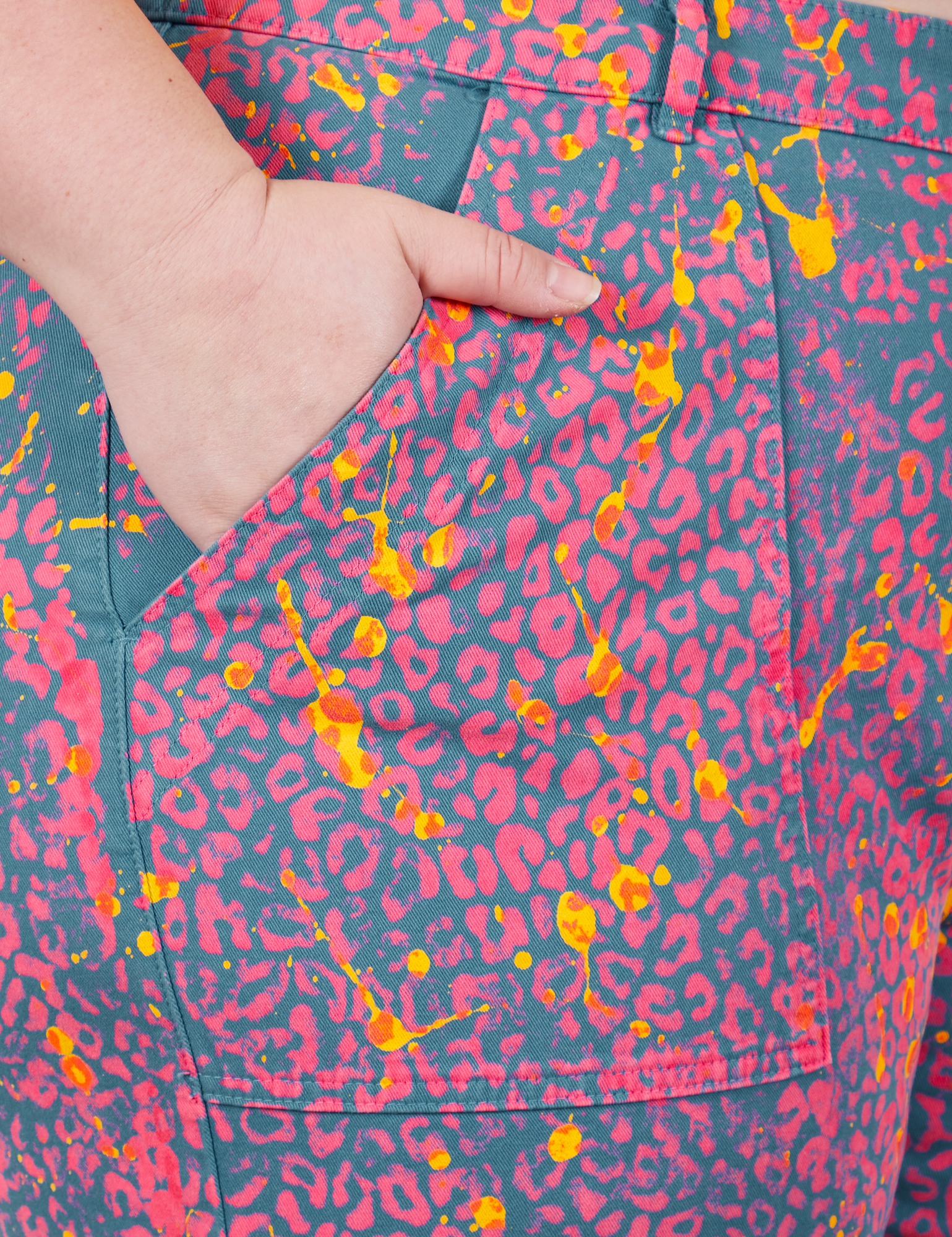 Work Pants in Electric Leopard front pocket close up. Ashley has her hand in the pocket.