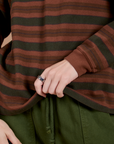 Long Sleeve Striped Burly Tee in Fudgesicle bottom close up with Alex holding the hem