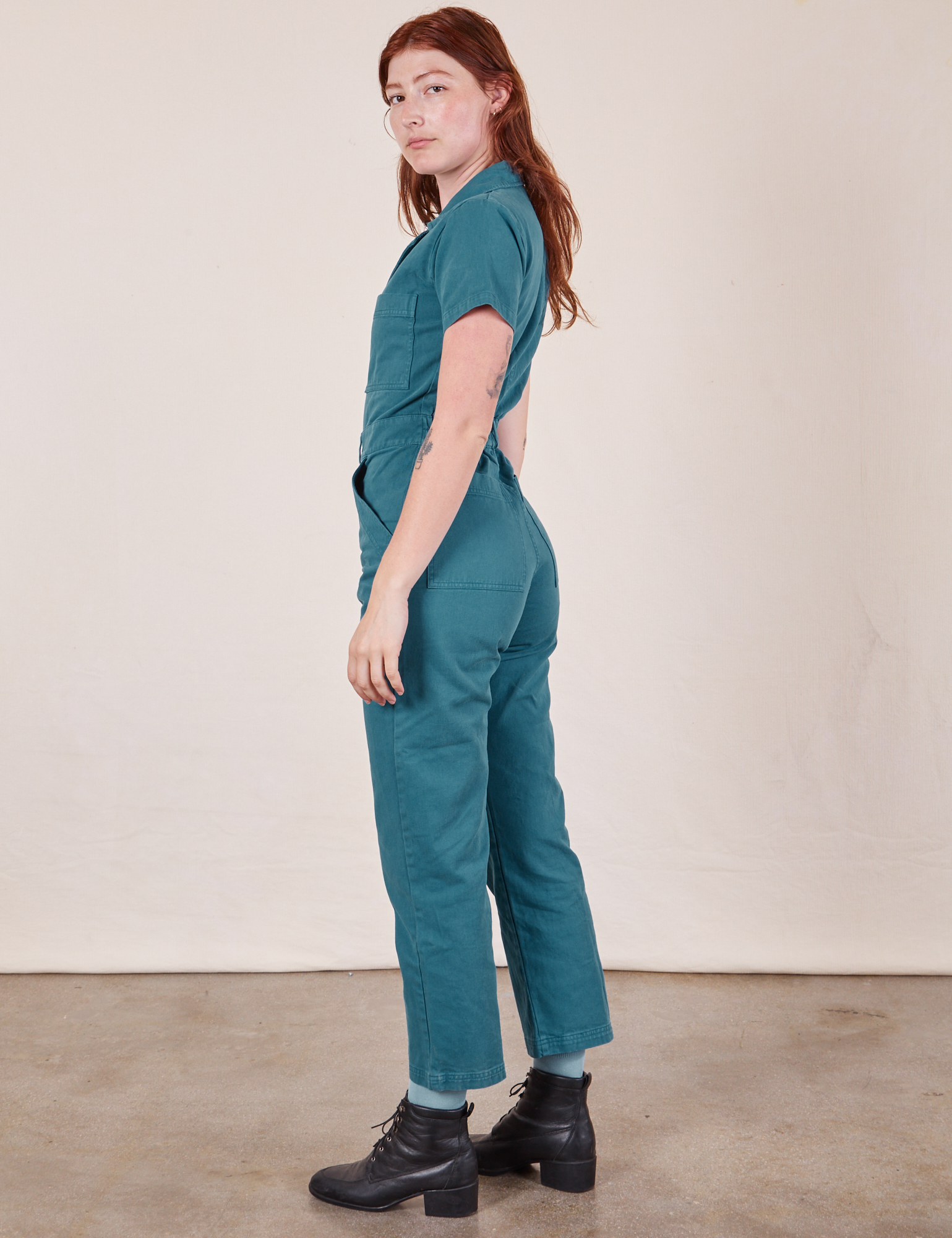 Side view of Short Sleeve Jumpsuit in Marine Blue worn by Alex