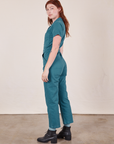 Side view of Short Sleeve Jumpsuit in Marine Blue worn by Alex