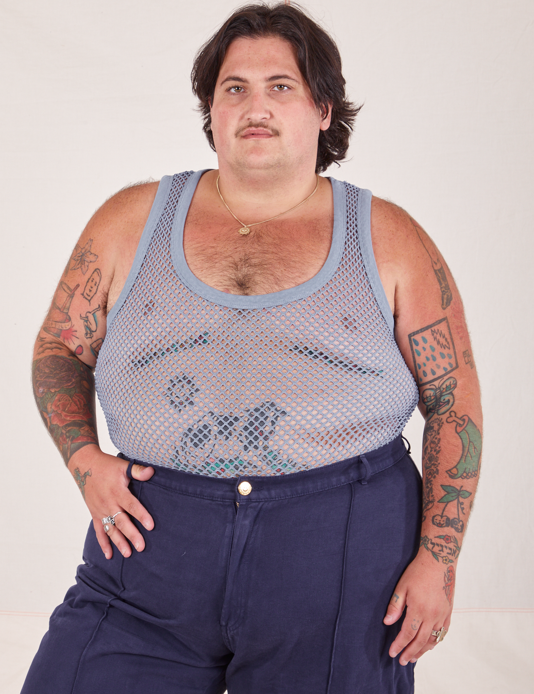 Sam is 5'10" and wearing XL Mesh Tank Top in Periwinkle paired with navy Western Pants