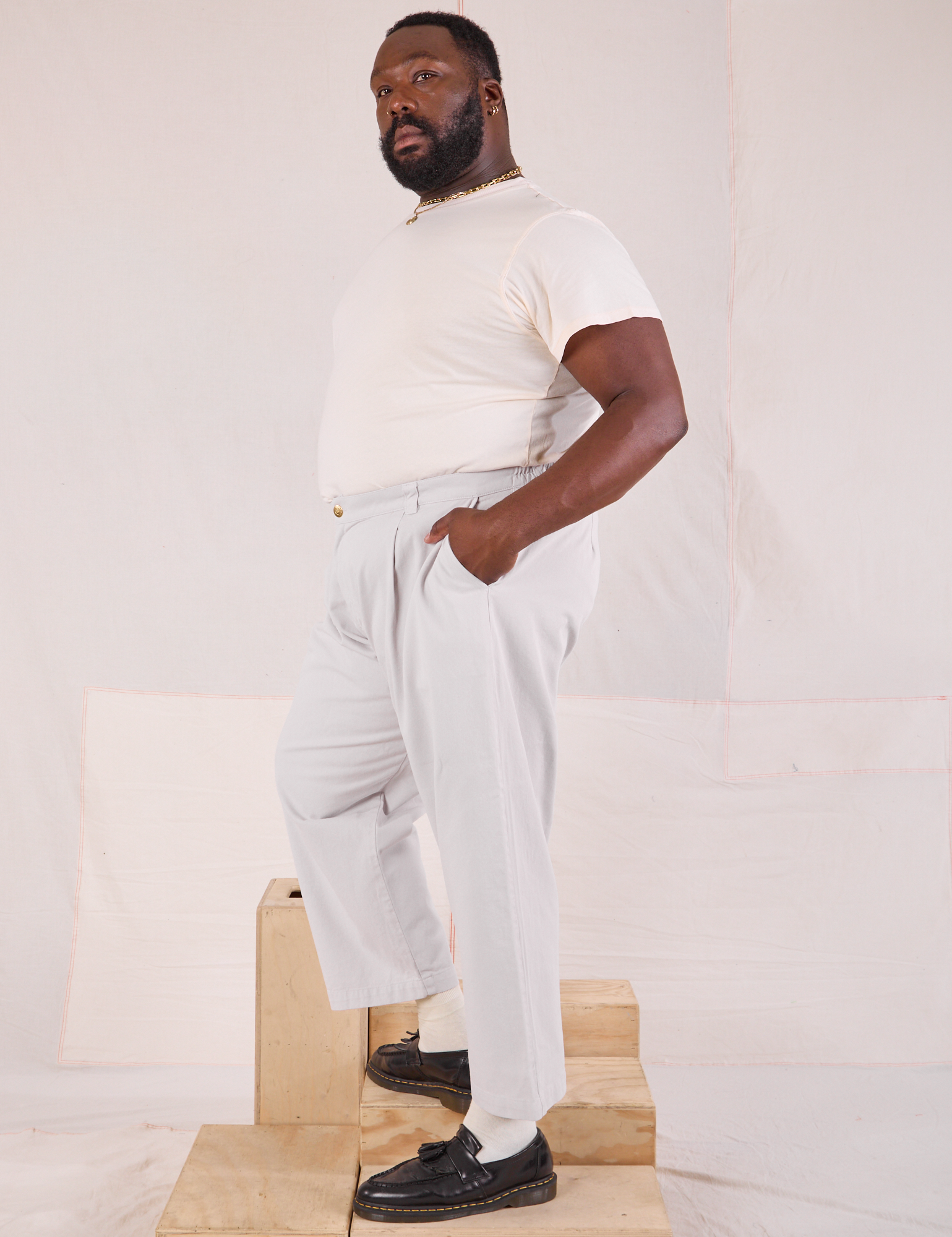 Side view of Mid-Rise Pleated Trousers in Stone White and Organic Vintage Tee in vintage tee off-white