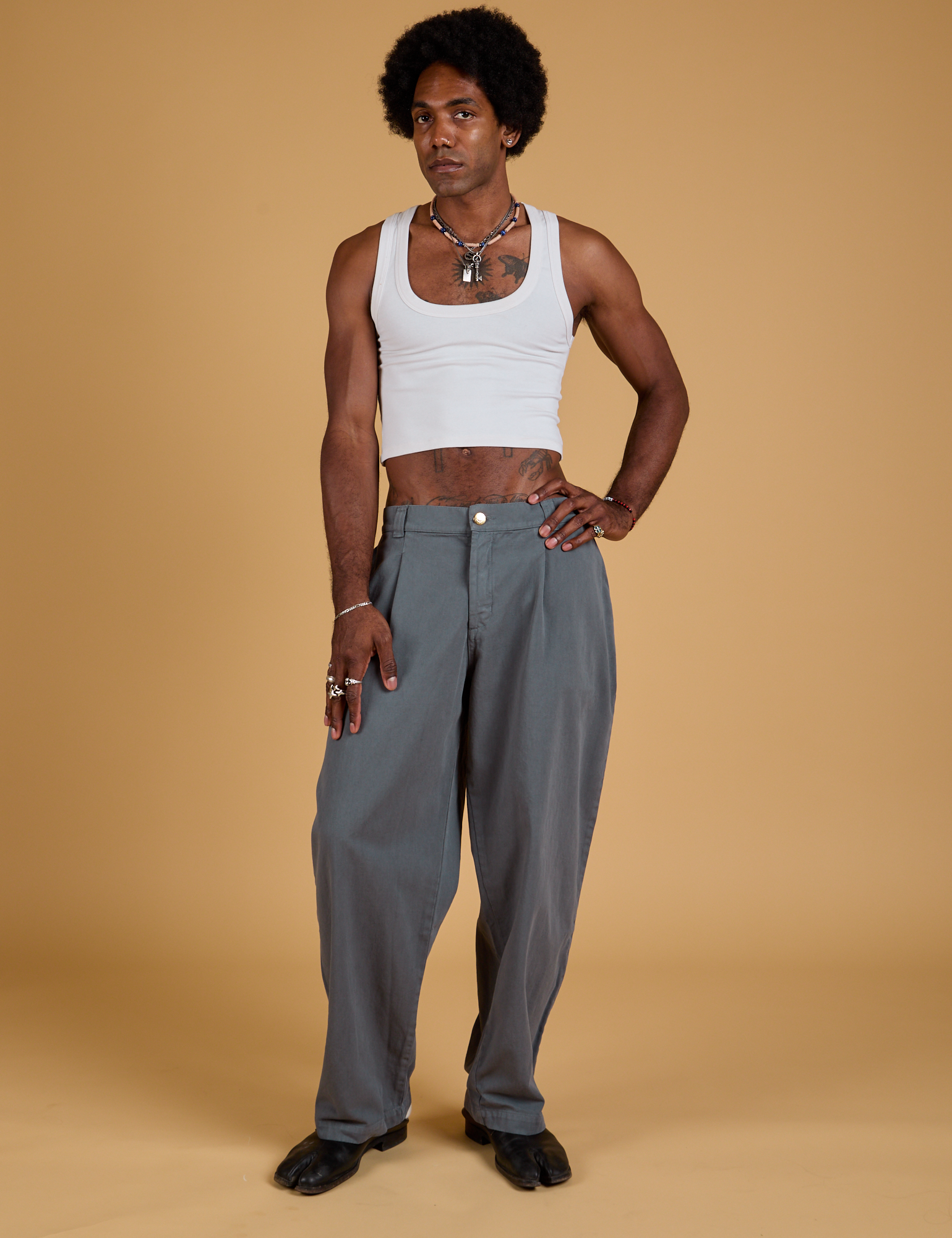 Jerrod is 6&#39;3&quot; and wearing M Baggy Mid-Rise Trousers in Slate Grey paired with a vintage tee white Cropped Tank