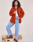 Jesse is wearing Oversize Overshirt in Paprika and light wash Denim Trousers