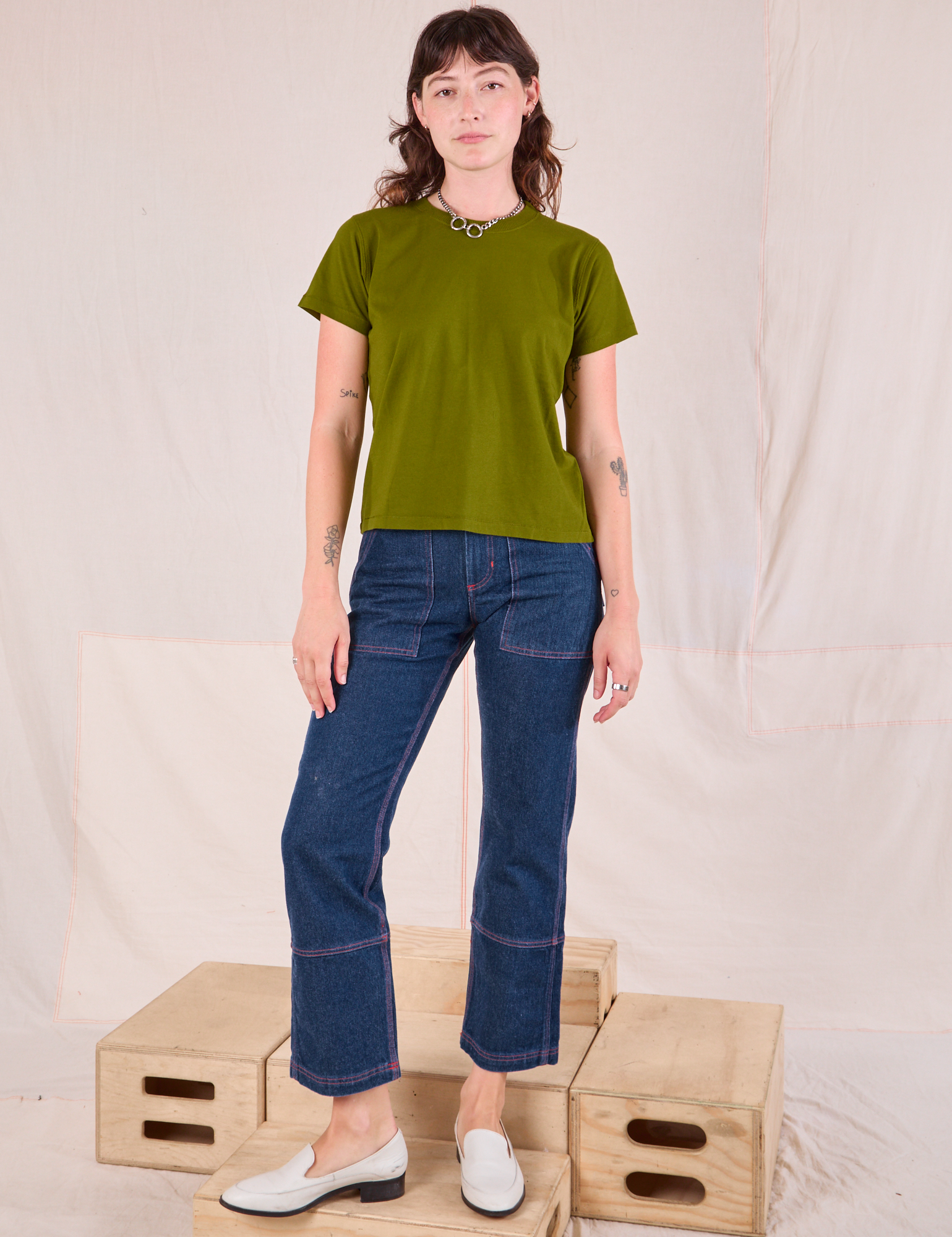 Alex is wearing Organic Vintage Tee in Summer Olive and dark wash Carpenter Jeans