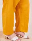 Bottom pant leg close up of Organic Trousers in Mustard Yellow worn by Ashley