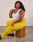 Work Pants in Golden Yellow on Morgan sitting on a wooden box