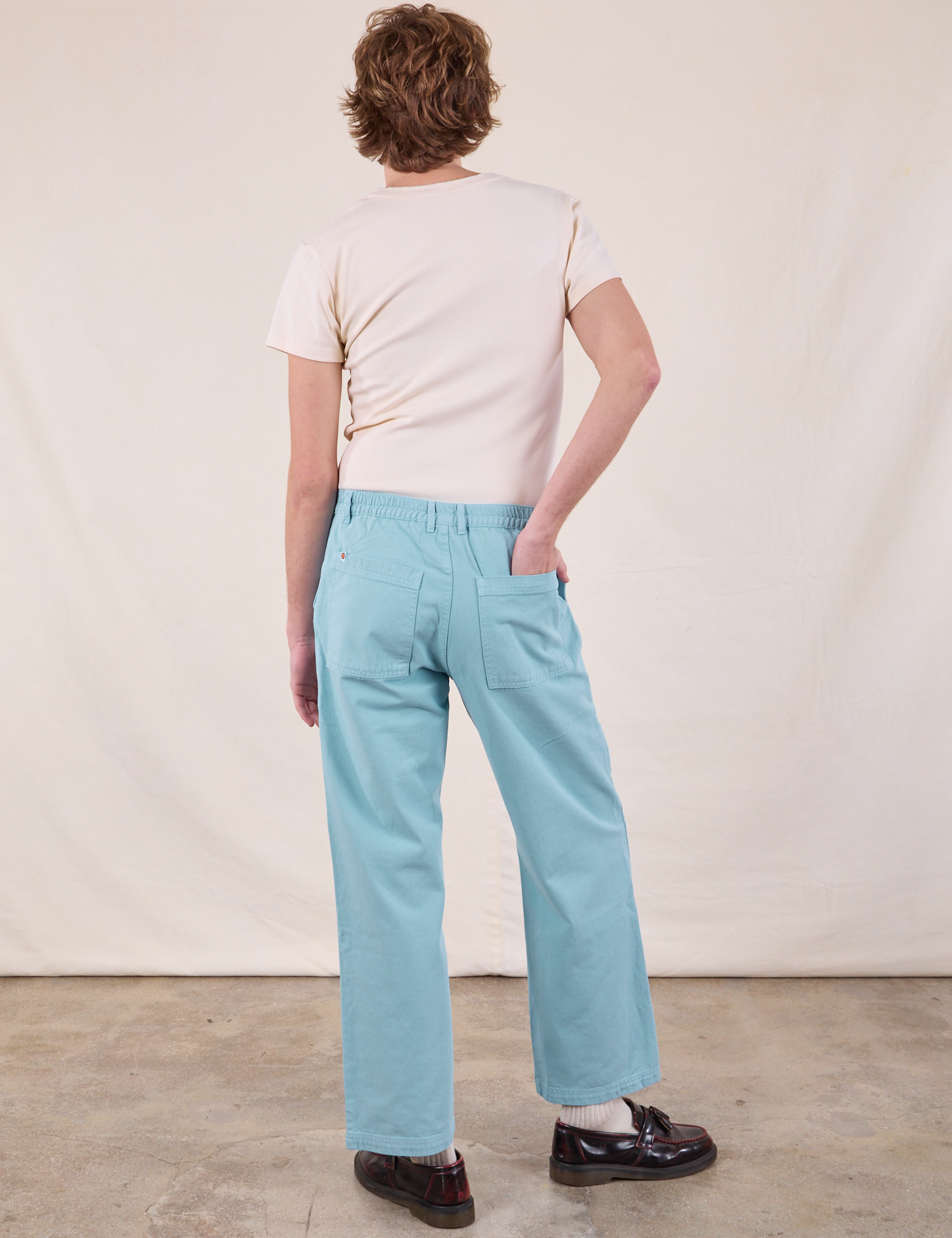 Back view of Work Pants in Baby Blue and Burly Tee in Vintage Tee Off-White on Quinn