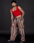 Angled front view of  Striped Drop Pocket Pants in Retro Rainbow and mustang red Cropped Tank on Jesse