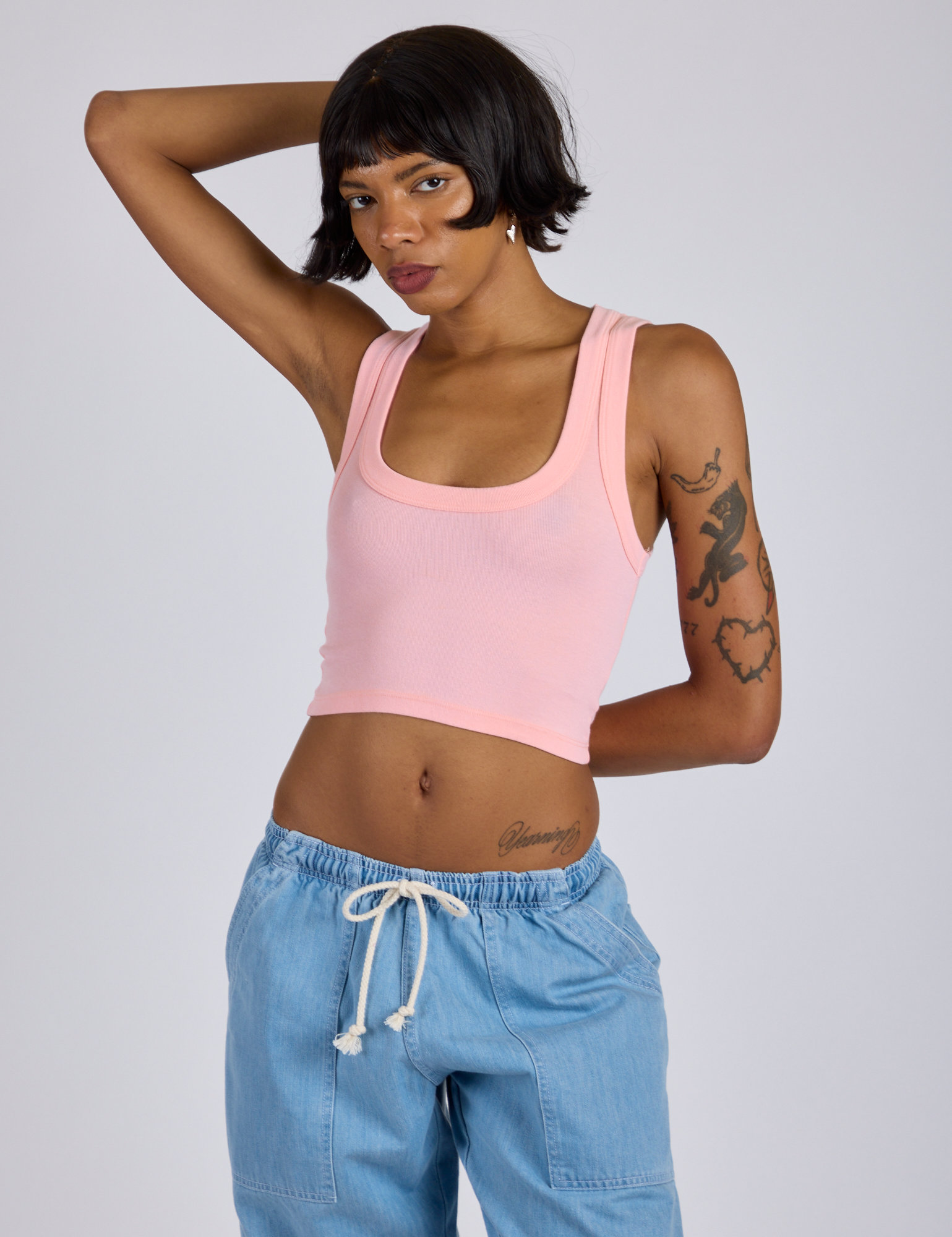 Kira is 5’10” and wearing P Cropped Tank Top in Baby Pink