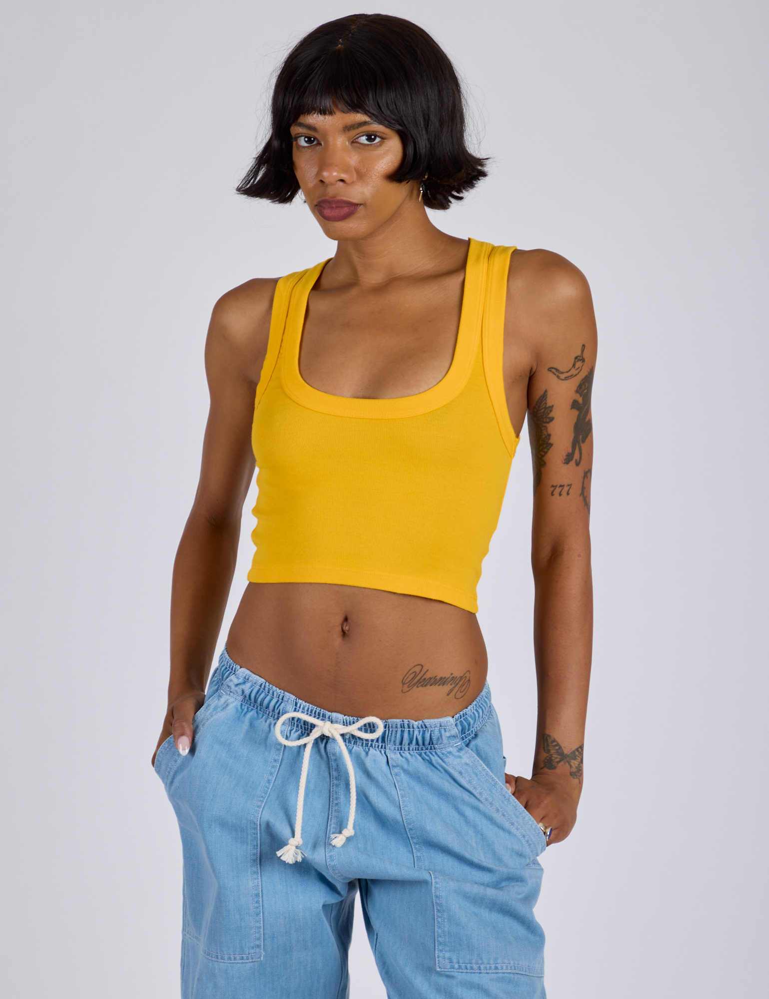 Kira is 5’10” and wearing P Cropped Tank Top in Sunshine Yellow