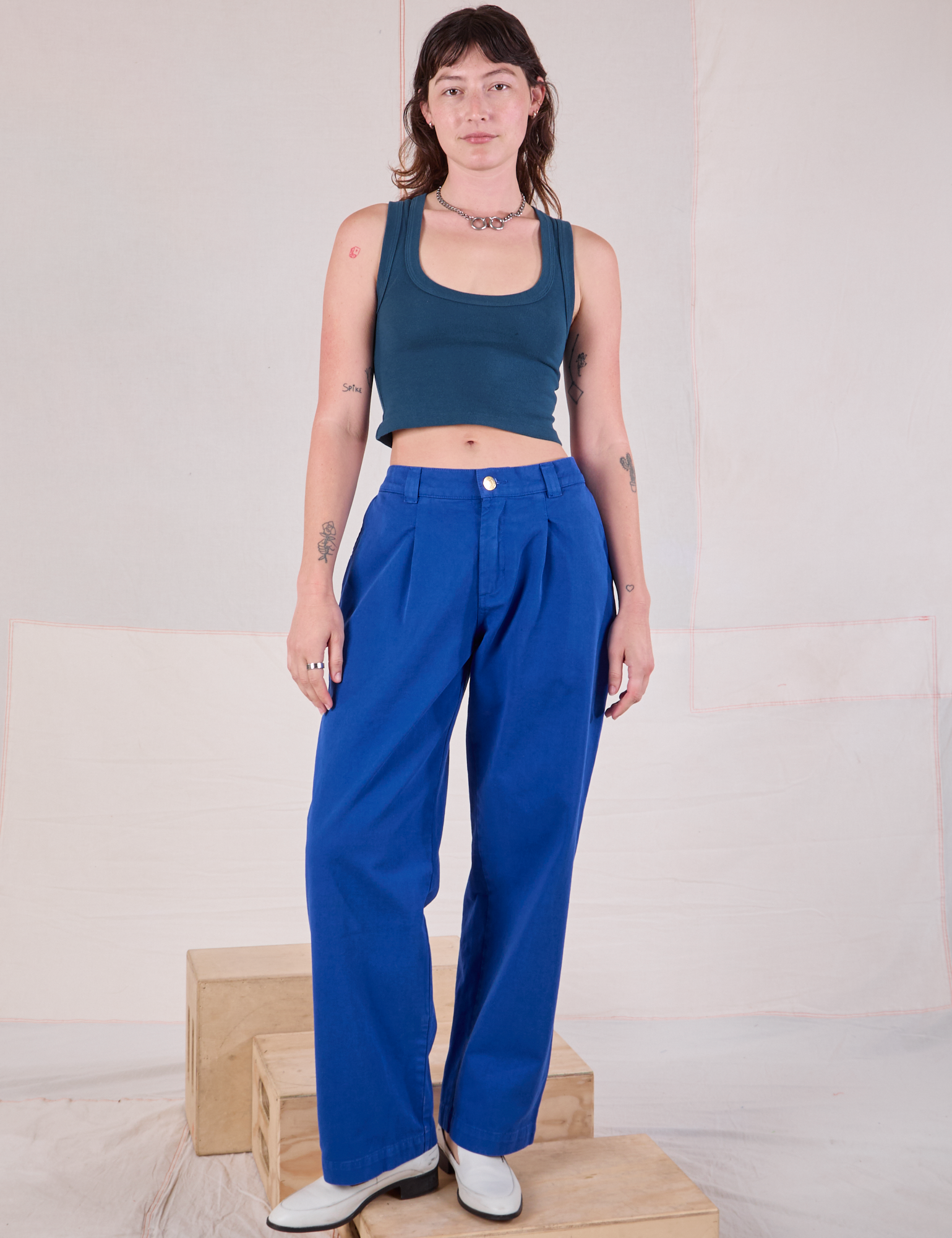 Alex is 5&#39;8&quot; and wearing XXS Mid-Rise Pleated Trousers in Royal Blue paired with a lagoon Cropped Tank