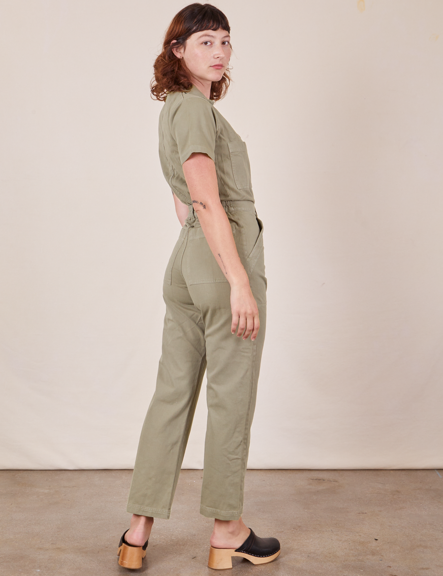 Angled back view of Short Sleeve Jumpsuit in Khaki Grey worn by Alex