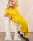 Juliet is wearing Short Sleeve Jumpsuit in Golden Yellow