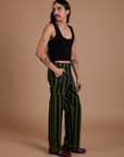 Side view of Black Stripe Work Pants in Evergreen and black Cropped Tank