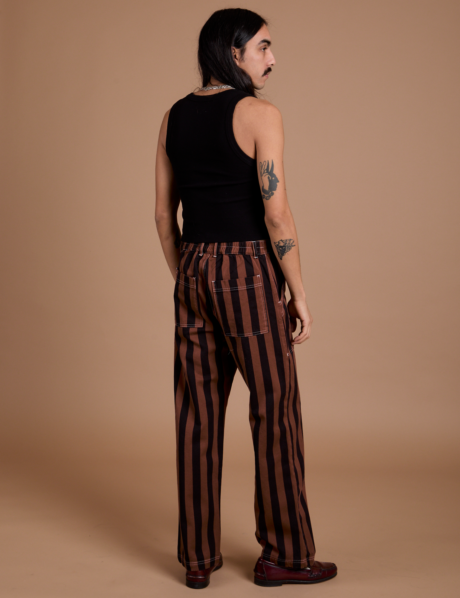 Back view of Black Stripe Work Pants in Fudgesicle Brown and black Cropped Tank on Anthony