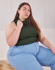 Marielena is wearing Sleeveless Essential Turtleneck in Swamp Green and light wash Trouser Jeans