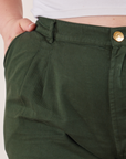 Trouser Shorts in Swamp Green front close up. Ashley has her hand in the pocket