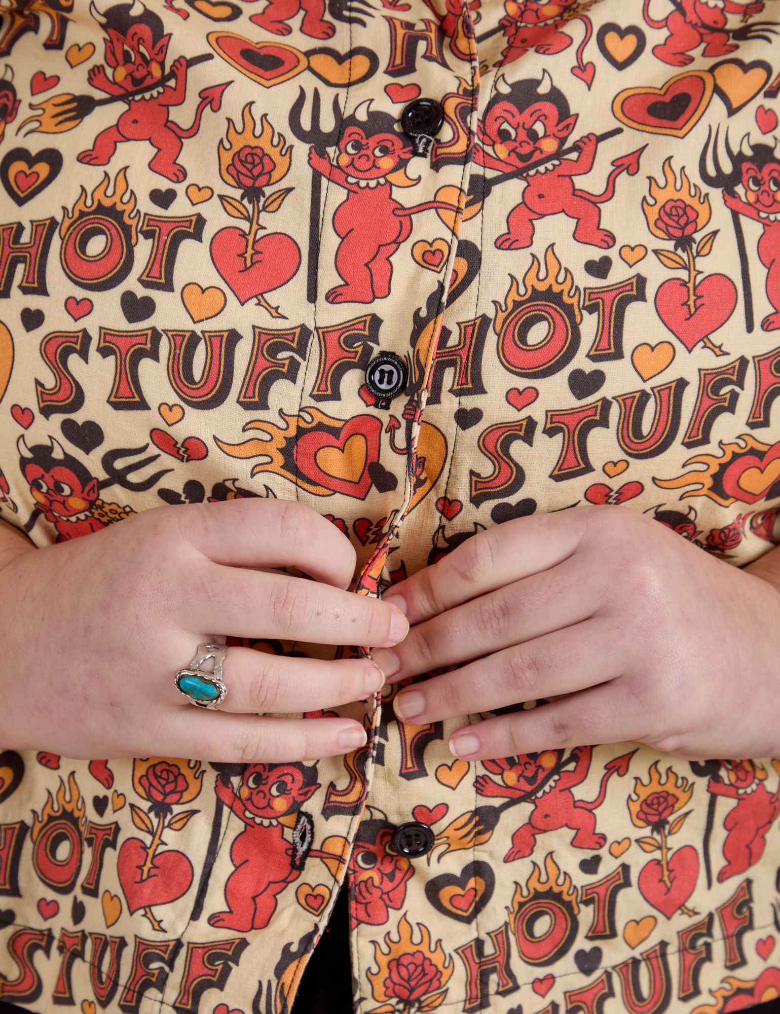 Close up of Juliet buttoning up the Hot Stuff Print Pantry Button-Up