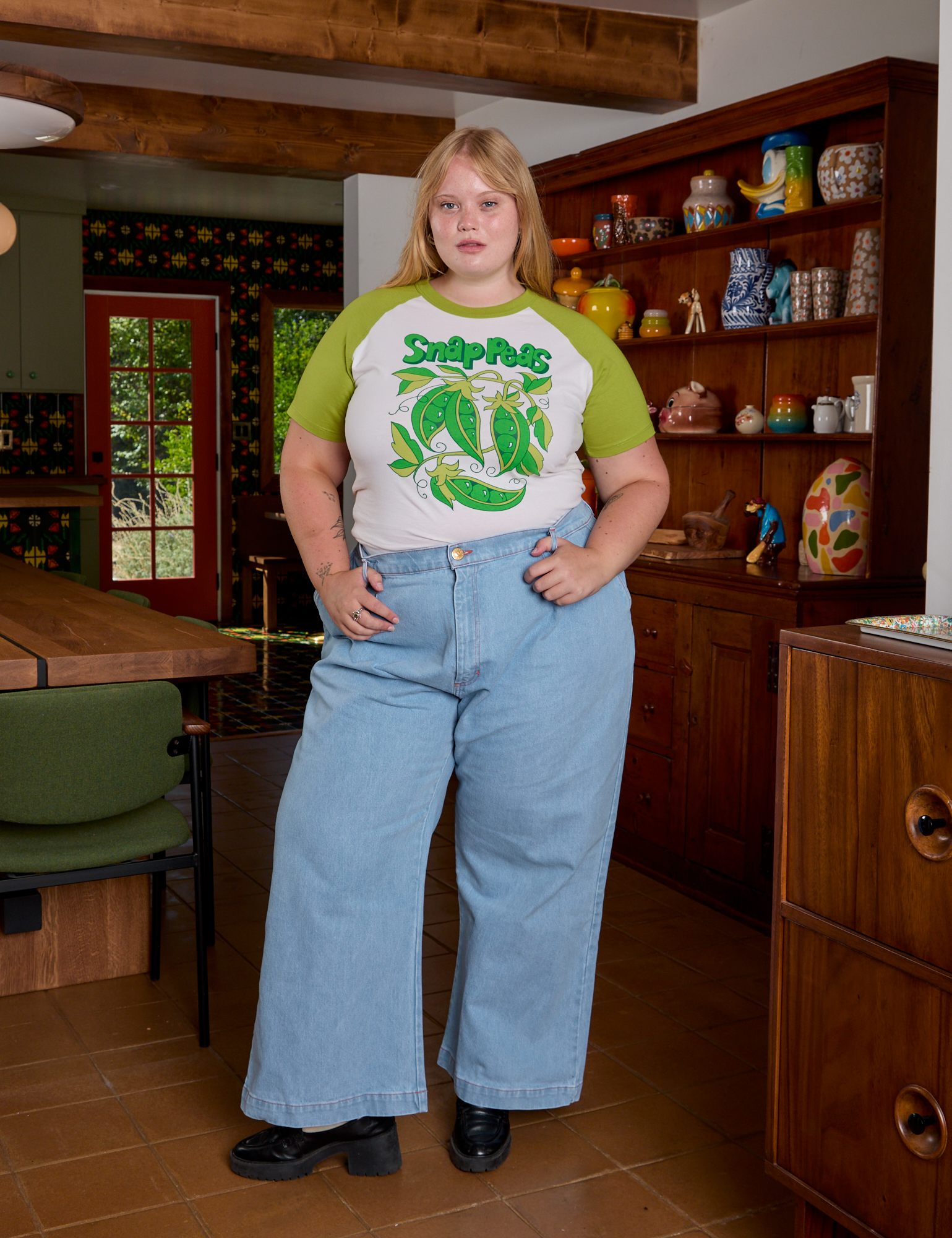 Juliet is wearing Short Sleeve Raglan Tee in Snap Peas tucked into light wash Indigo Wide Leg Trousers
