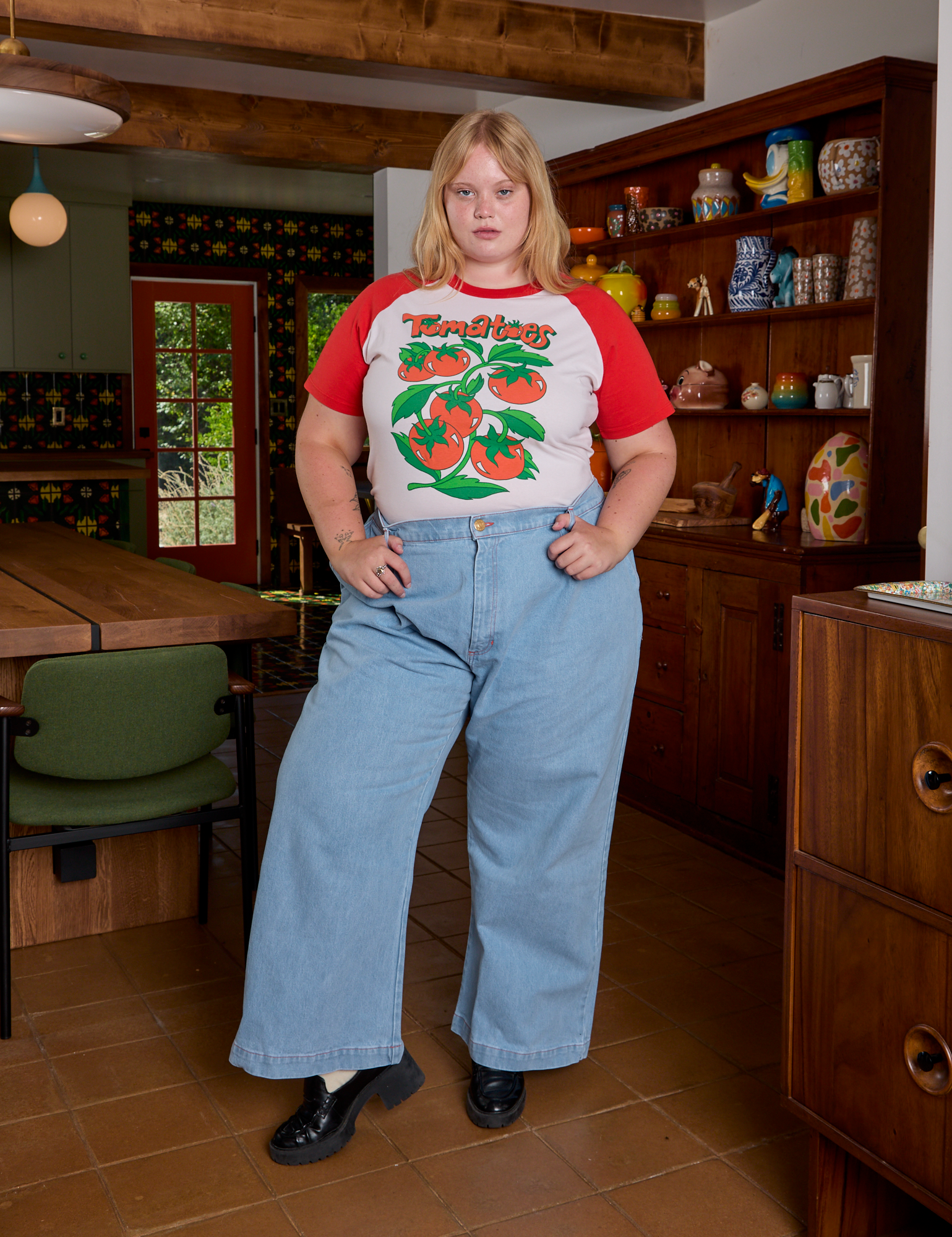 Juliet is wearing Short Sleeve Raglan Tee in Tomatoes tucked into light wash Indigo Wide Leg Trousers
