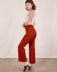 Side view of Western Pants in Paprika and vintage off-white Tank Top worn by Alex