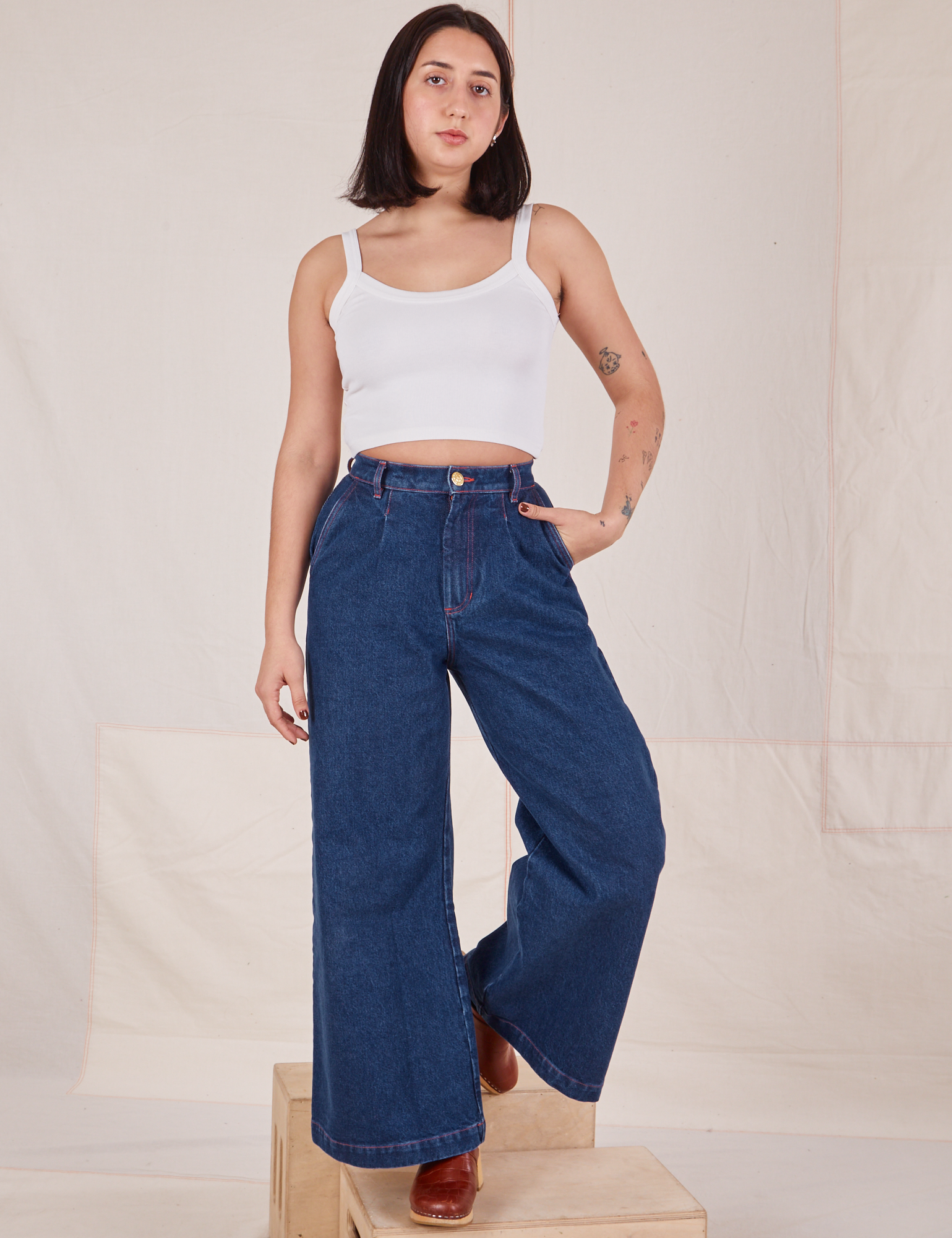 Betty is 5&#39;8&quot; and wearing XXS Indigo Wide Leg Trousers in Dark Wash paired with vintage off-white Cami