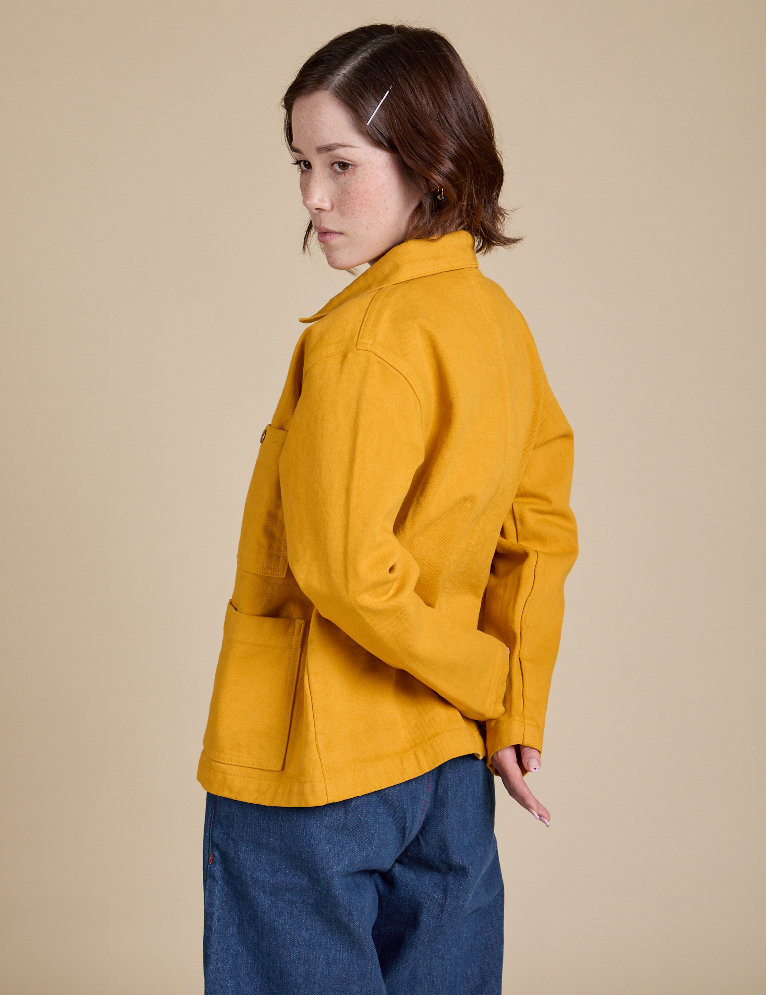 Angled back view of Denim Work Jacket in Mustard Yellow on Hana