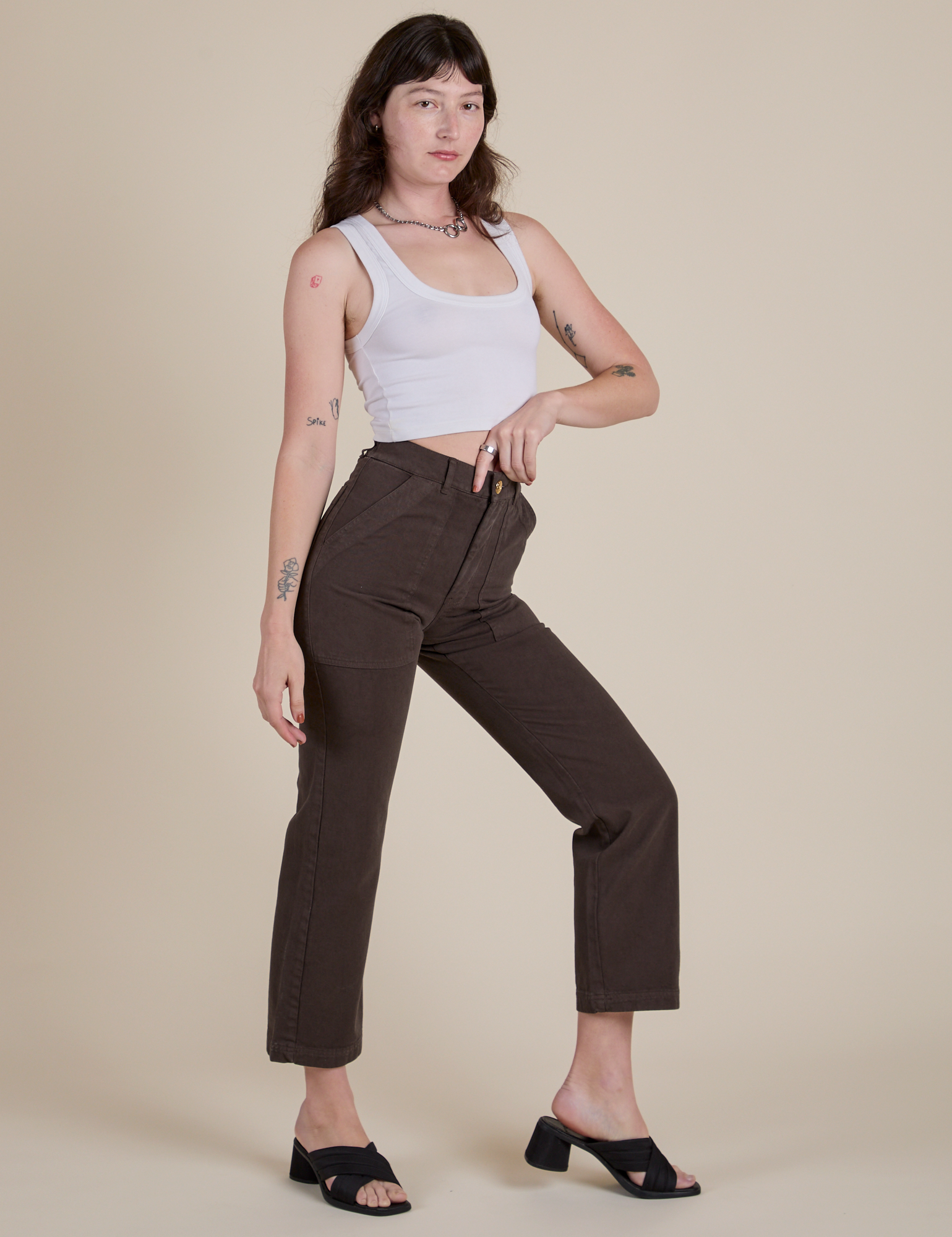 Angled front view of Work Pants in Espresso Brown and Cropped Tank in Vintage Tee White on Alex