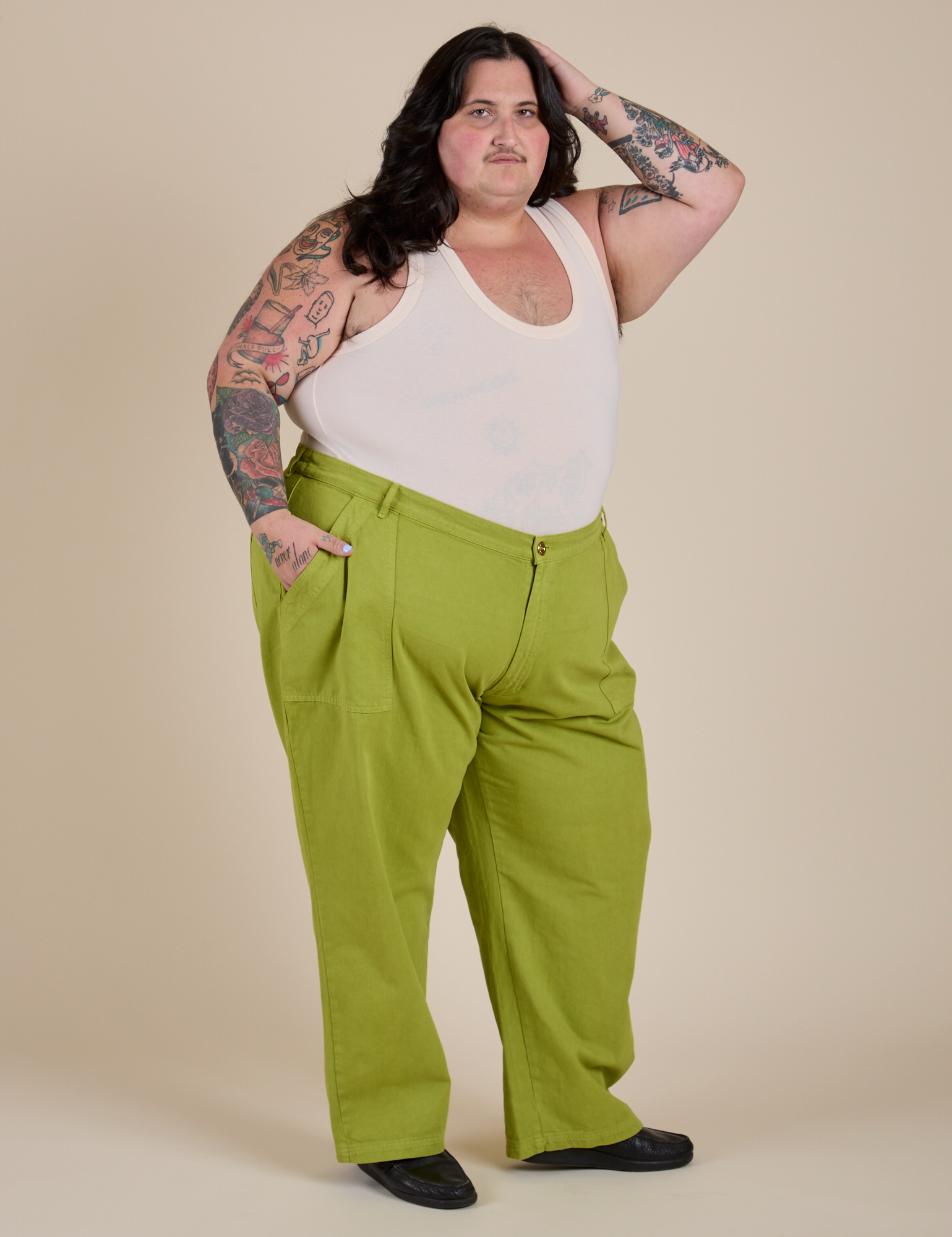 Angled front view of Work Pants in Gross Green and Cropped Tank in Vintage Tee White on Sam