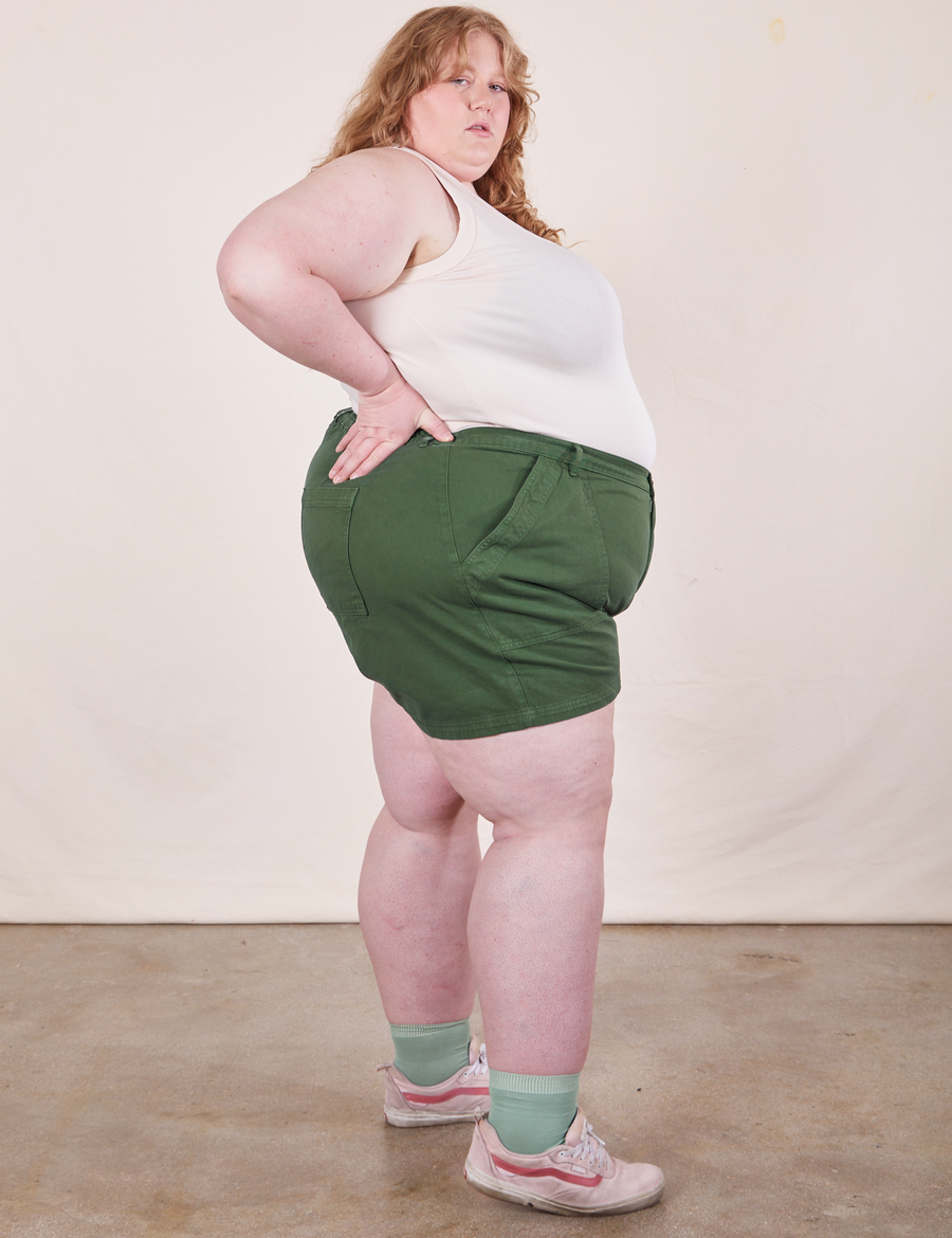Side view of Classic Work Shorts in Dark Emerald Green and vintage off-white Tank Top worn by Catie