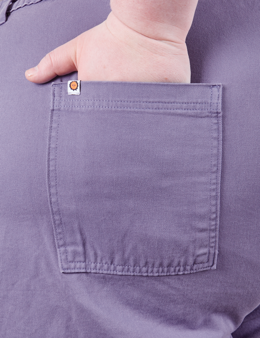 Catie has her hand in the back pocket of the Classic Work Shorts in Faded Grape