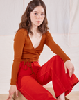 Hana is wearing Wrap Top in Burnt Terracotta and mustang red Bell Bottoms