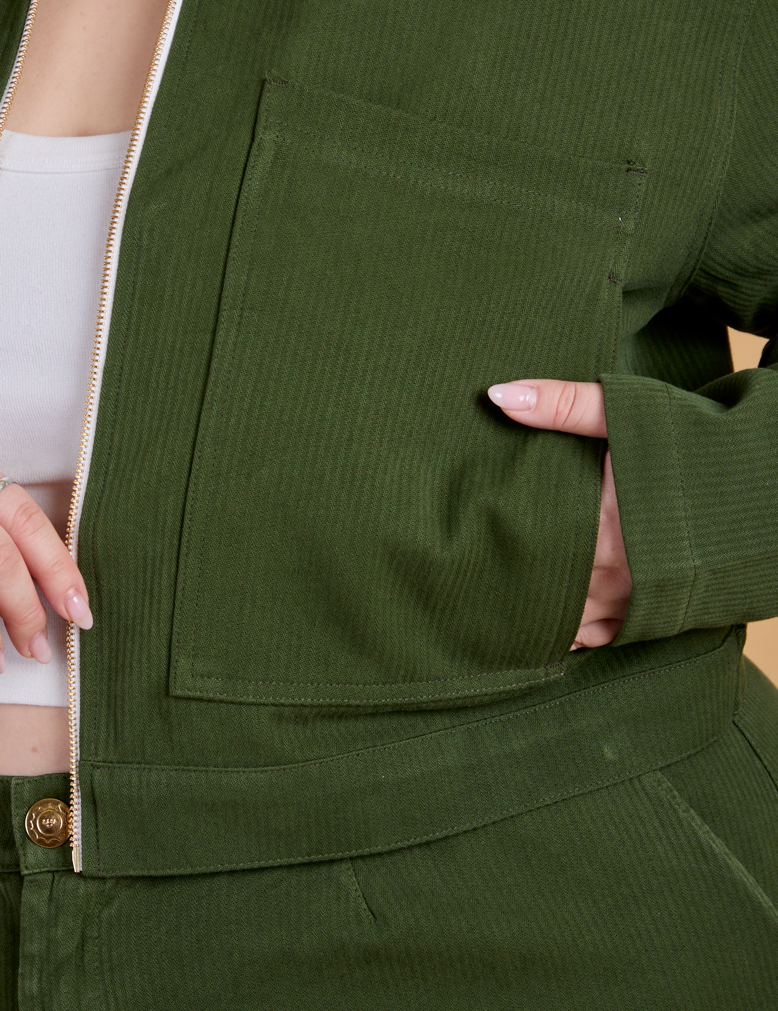 Close up of Ashley&#39;s hand in the front pocket of Heritage Mechanic Jacket in Evergreen