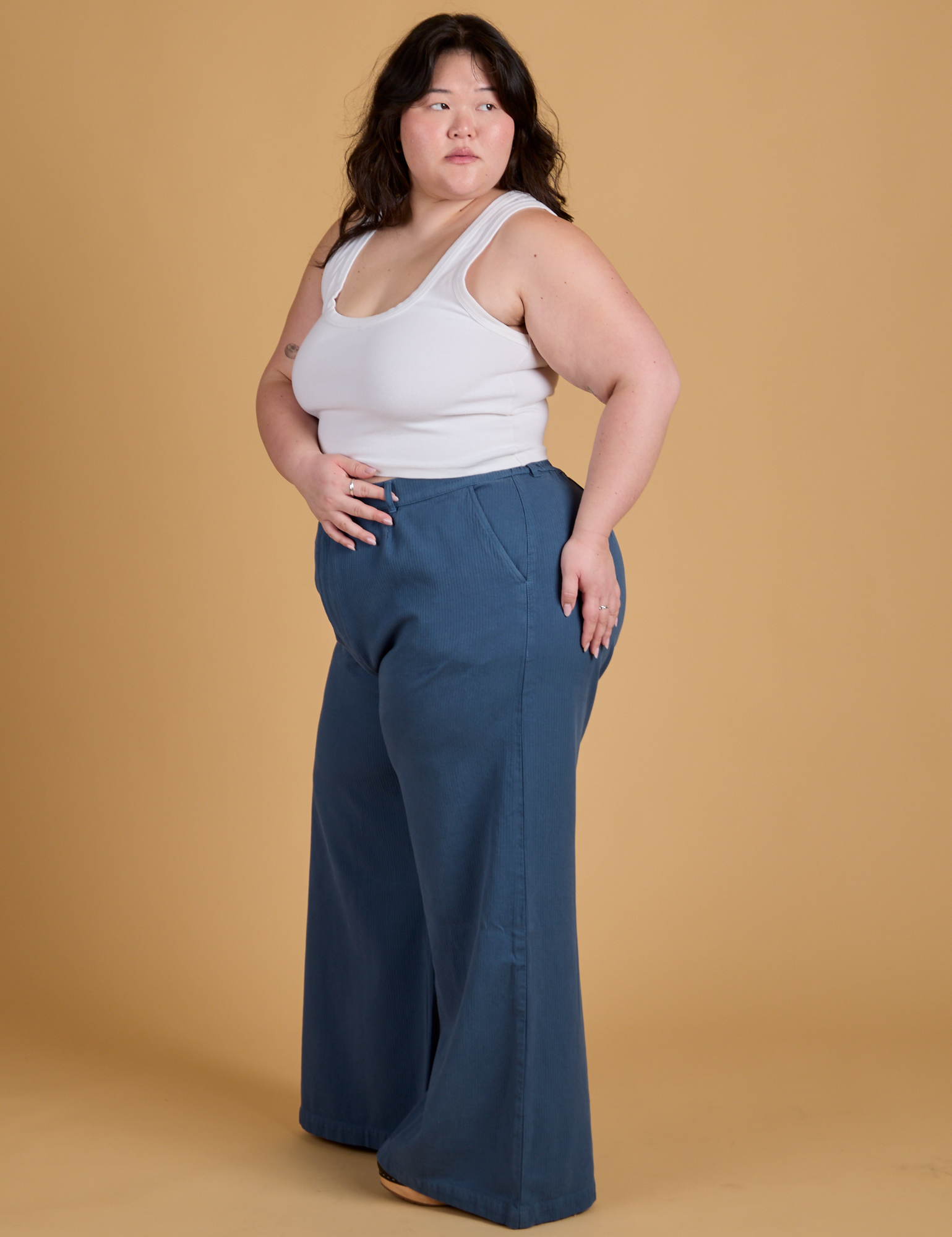 Side view of Heritage Wide Leg Trousers in French Blue and vintage tee white Cropped Tank on Ashley