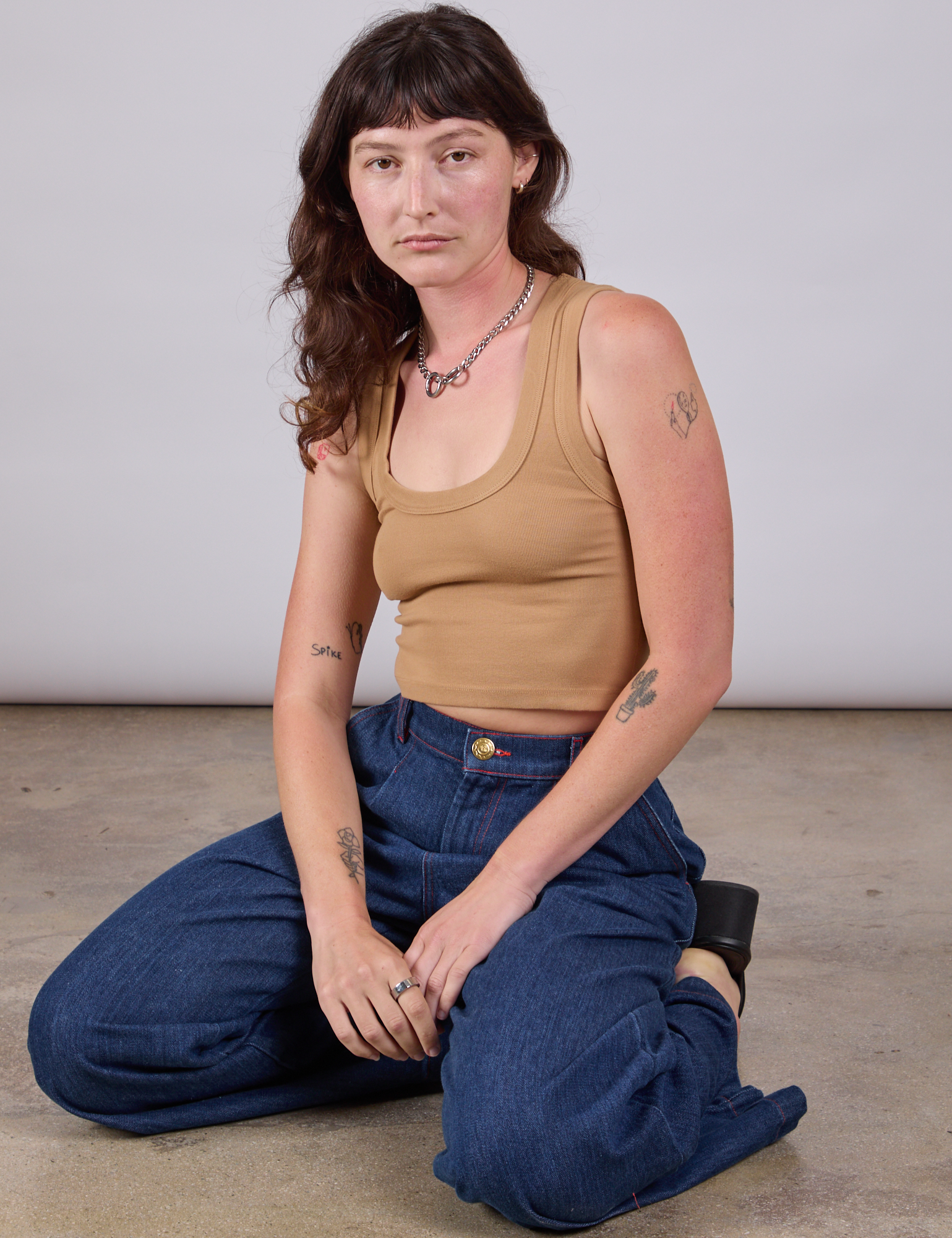 Alex is wearing Cropped Tank Top in Tan and dark wash Indigo Wide Leg Trousers