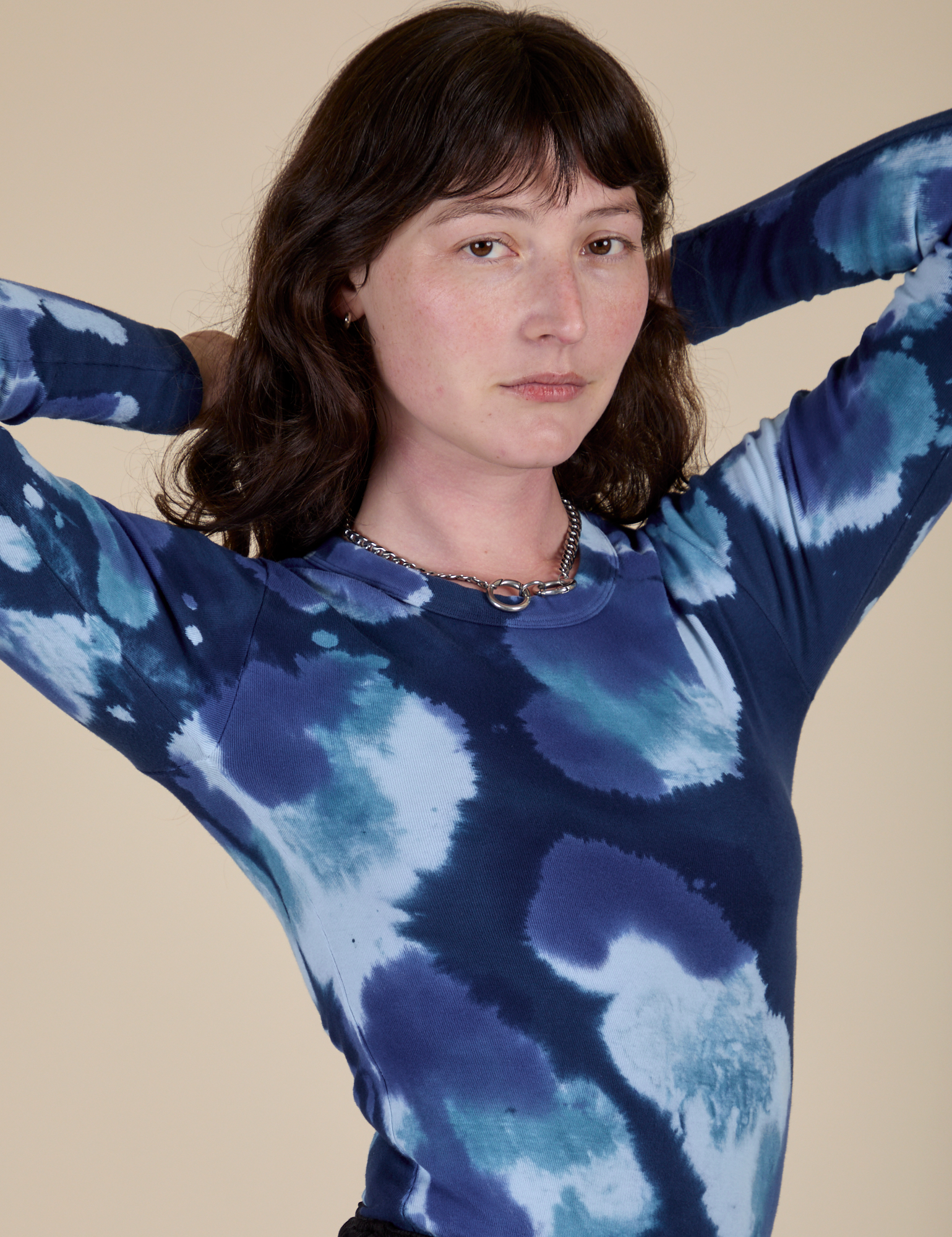 Angled front view of Long Sleeve Baby Tee in Blue Magic Waters on Alex