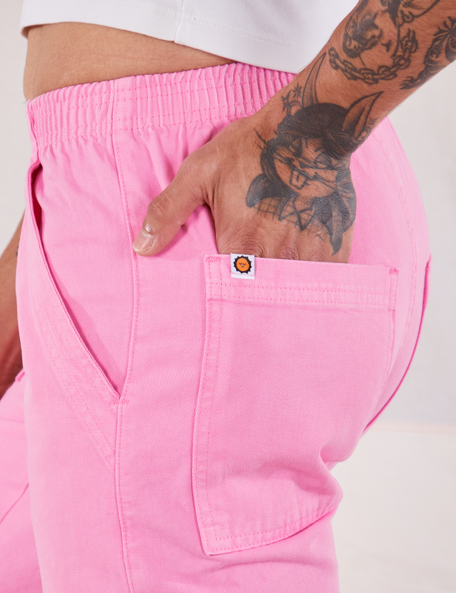 Action Pants in Bubblegum Pink side close up. Jesse has their hand in the back pocket.