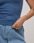 Close up of Alex holding the bottom hem of Baby Tee in French Blue