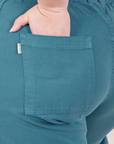Petite Bell Bottoms in Marine Blue back pocket close up. Ashley has her hand in the pocket.