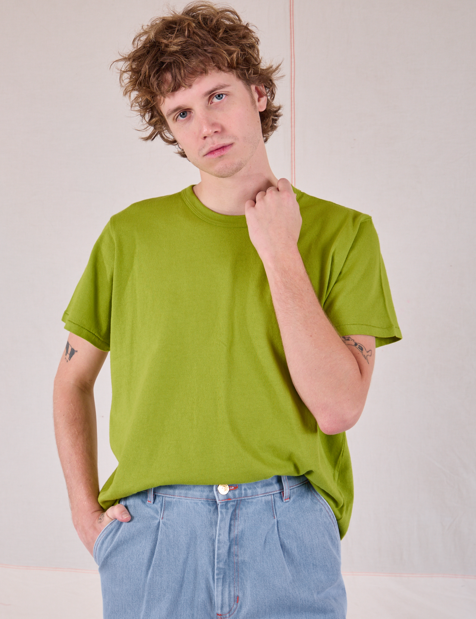 Burly Tee in Gross Green tucked into light wash Denim Wide Leg Trousers