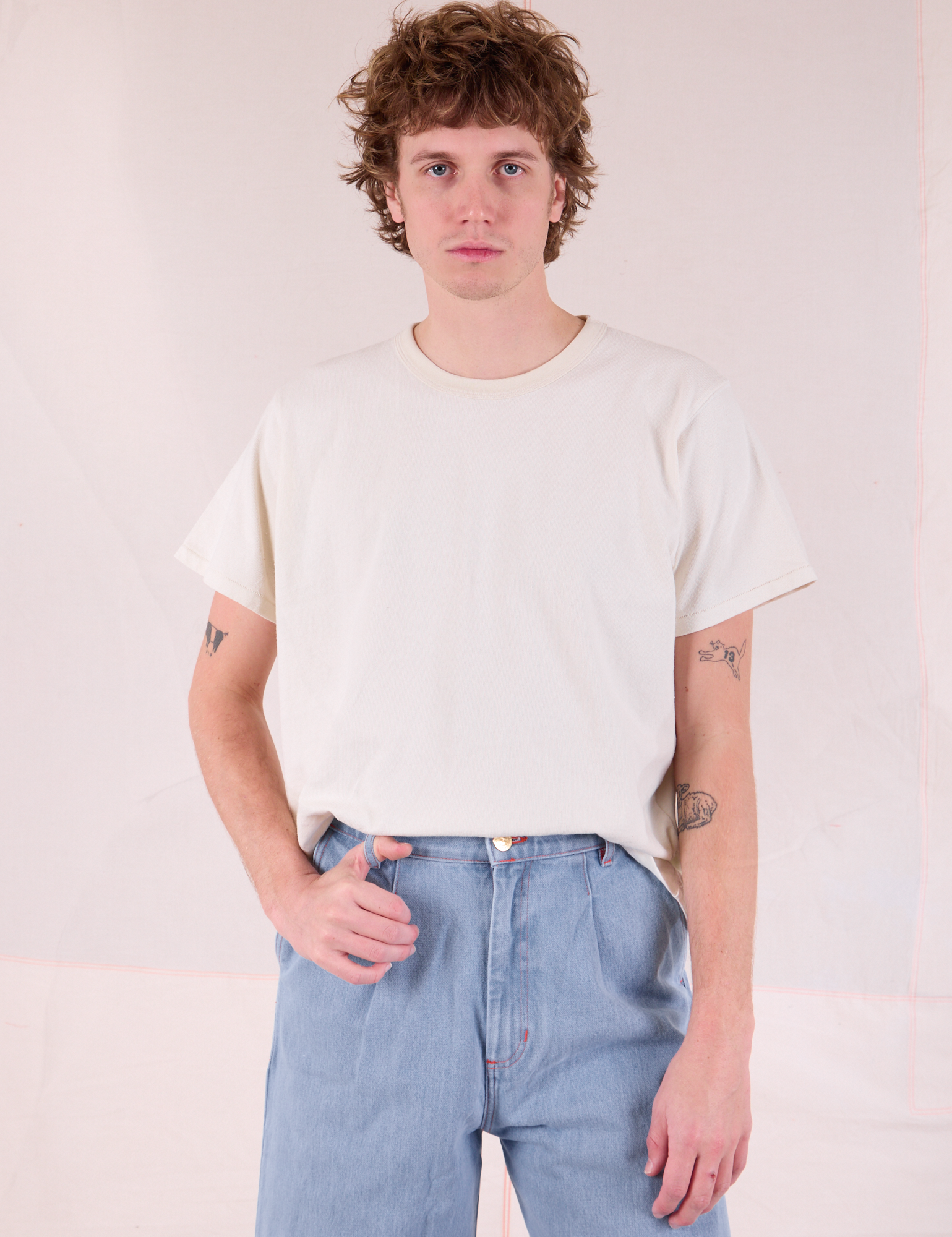 Quinn is wearing Burly Tee in Vintage Tee Off-White tucked into light wash Denim Wide Leg Trousers